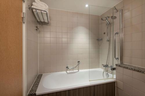 a bathroom with a bath tub with a shower at Radisson Blu Manchester Airport in Hale