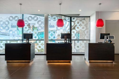 a salon with red lamps and a large window at Radisson Blu Manchester Airport in Hale