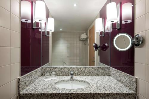 a bathroom with a sink and a mirror at Radisson Blu Manchester Airport in Hale