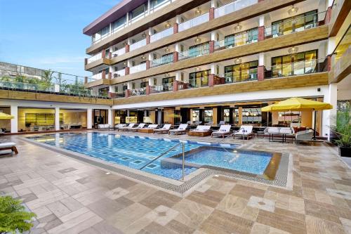 a large swimming pool in front of a building at Radisson Resort Goa Baga in Baga