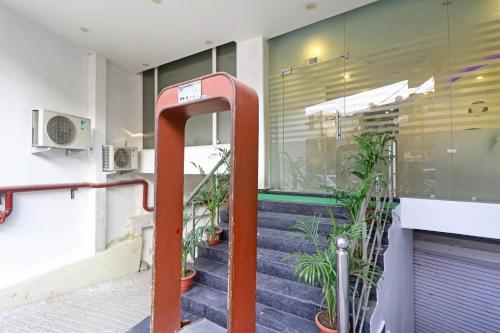 a red hand rail in front of a building with plants at Kelvish Hotel-Delhi Airport in New Delhi