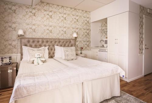 a white bedroom with a teddy bear sitting on a bed at Freys Hotel in Stockholm