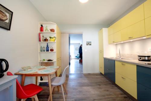 une cuisine avec des armoires jaunes, une table et des chaises dans l'établissement Azura, à San-Martino-di-Lota