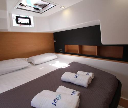 a large bed in a boat with two towels on it at Marina Yacht Charter in Rosignano Solvay