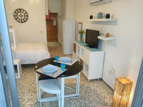 トレモリノスにあるEstudio Vistas al Marの小さなテーブルとベッドルームが備わる小さな客室です。