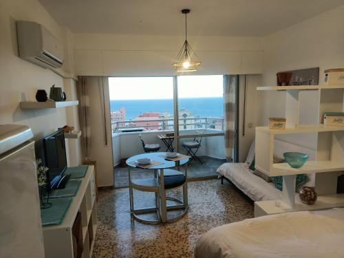 トレモリノスにあるEstudio Vistas al Marのテーブル、景色を望むキッチンが備わる小さな客室です。