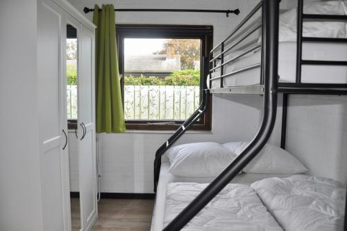 een slaapkamer met een stapelbed en een raam bij Boerenslag 10 in Sint Maartensvlotbrug