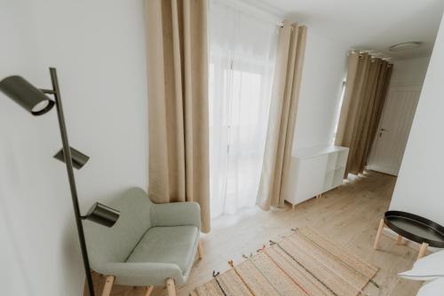 - un salon avec une chaise et une fenêtre dans l'établissement Casa Botár Vendégház, à Rimetea