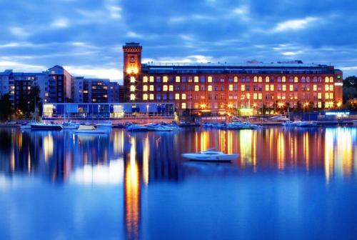 a large building with boats in the water at night at Lapinniemen kattohuoneistot Tampereella in Tampere