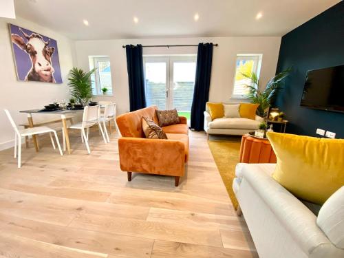 a living room with couches and a dining room at Amazing NEW Large 2 bedroom House - 5 Minutes to the nearest Beach! - Great Location - Garden - Parking - Fast WiFi - Smart TV - Newly decorated - sleeps up to 5! Close to Poole & Bournemouth & Sandbanks in Lytchett Minster