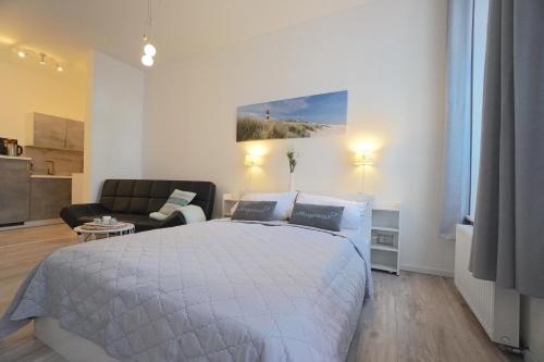 a bedroom with a bed and a living room with a couch at Apartment THOR am Schleswiger Dom in Schleswig