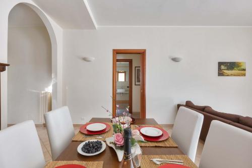 a dining room with a wooden table with white walls at Villa Irma with private pool in Noci