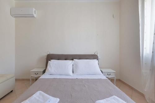 a white bedroom with a bed with two night stands at Villa Irma with private pool in Noci