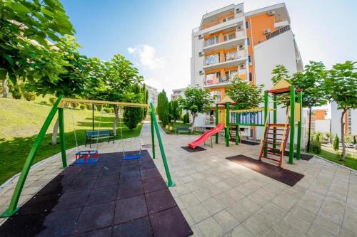 - une aire de jeux avec toboggan et balançoire dans l'établissement Fort Noks - Menada Apartments, à Sveti Vlas