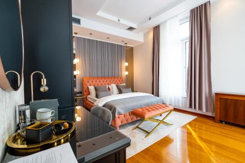 ein Schlafzimmer mit einem Bett und einem Schreibtisch in einem Zimmer in der Unterkunft NATALI Luxury suites in Belgrad