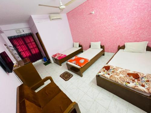 Habitación con 2 camas y una silla. en Hotel Green Land, en Bāndarban