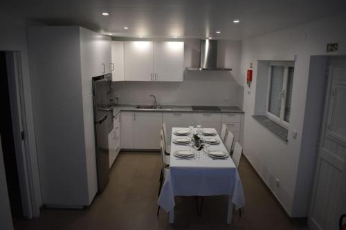 a kitchen with a table with a white table cloth at Casa do Sapateiro in Ferrel