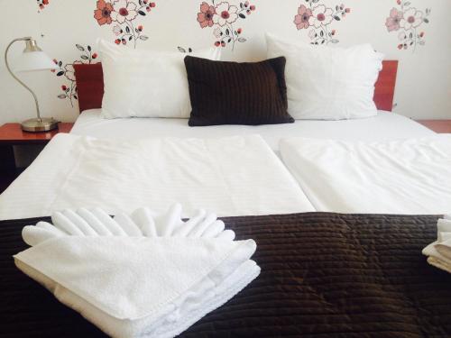 a white bed with two white towels on it at Canada Hotel Budapest in Budapest