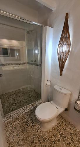 a bathroom with a toilet and a glass shower at Casa Pescador Beach House in Struisbaai