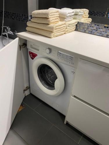 a washing machine under a counter with towels on it at 2 bedroom apartment close to center, park and shopping center in Chişinău