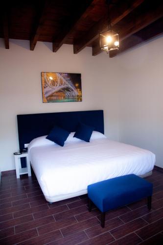 a bedroom with a large white bed with blue pillows at Noches en Triana in Seville