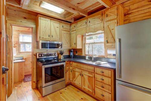 cocina con armarios de madera y nevera en Log Cabin with Mountain View and Privacy, en Blue Ridge