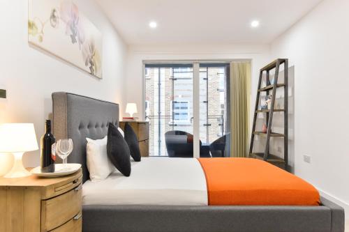 a bedroom with a bed and a desk and a window at Paddington Gardens in London