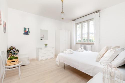 ein weißes Schlafzimmer mit einem weißen Bett und einem Stuhl in der Unterkunft [LIDO DI FERMO-FREE PARKING] Appartamento miramare in Lido di Fermo