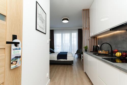 a kitchen with a sink and a bedroom with a bed at Dream Team Industria in Bydgoszcz