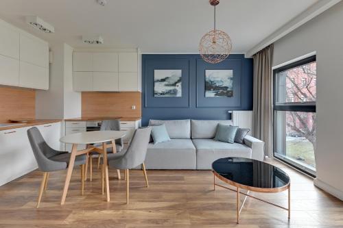 a living room with a couch and a table at Dom & House - Apartments Winter Residence in Gdańsk
