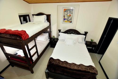 a bedroom with two bunk beds in a room at Hotel Aroma del Bosque Posada Cafe in Tunja