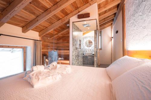 una camera da letto con un grande letto bianco e uno specchio di Chalet Noèr a Ledro