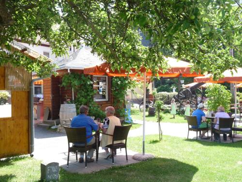 a group of people sitting at a table under a tree at Hotel zur Kanone in Tautenhain