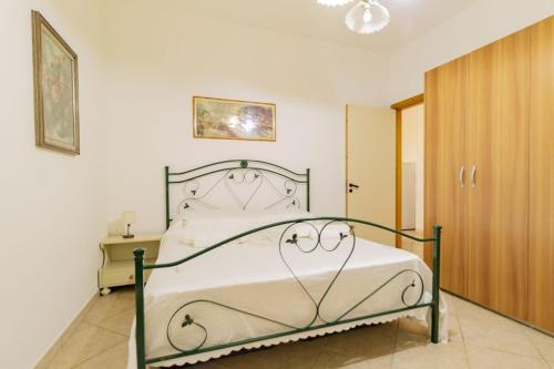 una camera con letto bianco con struttura metallica di Casa vacanze Nonna Nella a Porto Cesareo