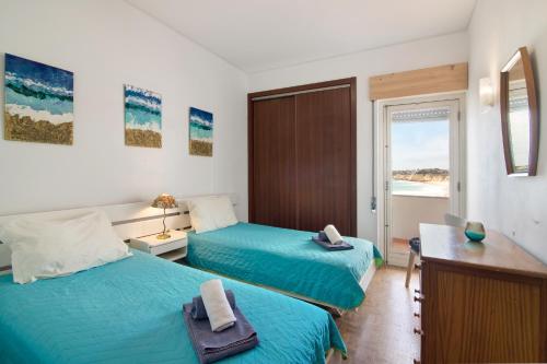 a bedroom with two beds with towels on them at Apartamento Caravela in Armação de Pêra