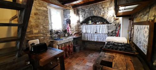 cocina con pared de piedra y fogones en b&b La Corte dei Cerri- Il Piccolo Chalet en Frassinoro