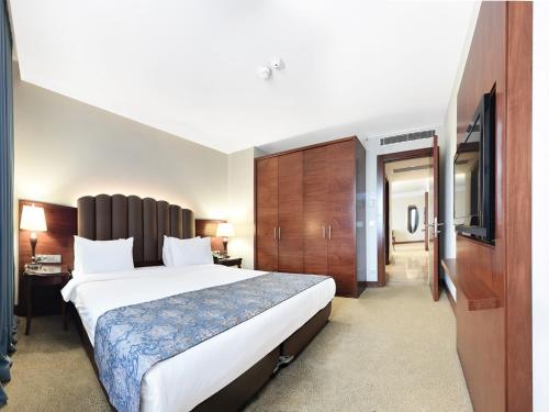 マラティヤにあるRamada Plaza Altin Kayisi Hotelの大型ベッドとテレビが備わるホテルルームです。
