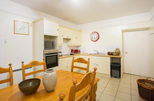 a kitchen with a wooden table and a dining room at The Mains in Elgin