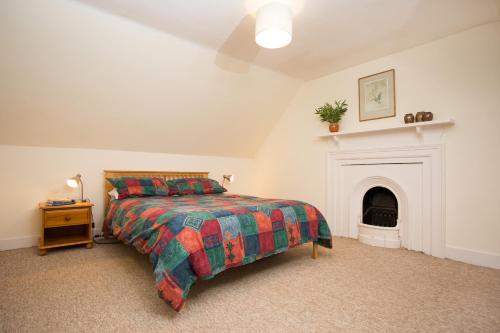 a bedroom with a bed and a fireplace at The Mains in Elgin