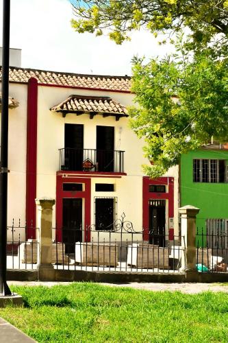 a white and red building with a balcony at Hotel Aroma del Bosque Posada Cafe in Tunja
