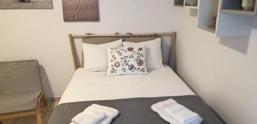 a small bed with two pillows and two towels on it at La Playa Studio Best location close to the Beach & center in Platis Yialos Mykonos