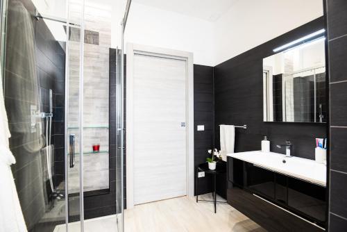 a bathroom with a glass shower and a sink at CDO Apartment in Capo dʼOrlando