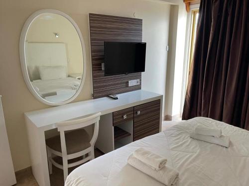 a bedroom with a mirror and a bed and a desk at Antonis G. Hotel Apartments in Voroklini