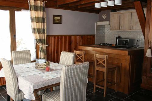 una cucina e una sala da pranzo con tavolo e sedie di Le Chalet Pré de la Fontaine a Paliseul