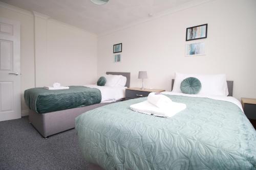 A bed or beds in a room at Family Home in the Charming Coastal Town of Barry