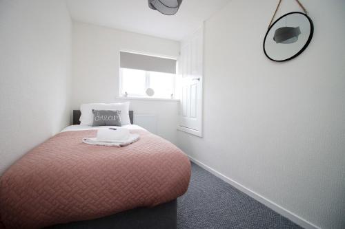 a bedroom with a bed with a mirror on the wall at Family Home in the Charming Coastal Town of Barry in Barry
