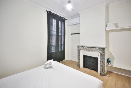 une chambre avec un lit et une cheminée dans l'établissement B0#Appart 4pers#Champs Elysées#Arc de Triomphe, à Paris
