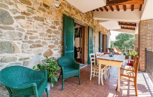 a patio with chairs and a table and a stone wall at Stunning Home In Scansano With Wifi in Scansano