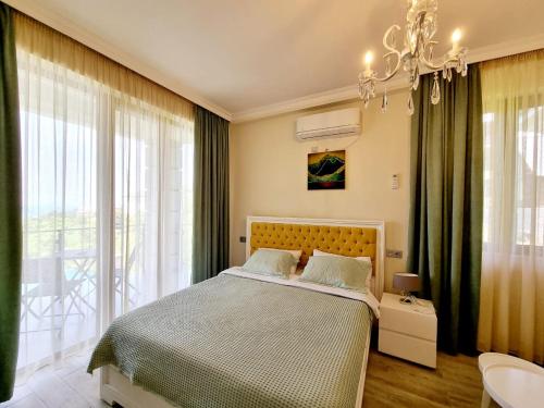 a bedroom with a bed and a chandelier at Guest House Botanical Paradise in Mtsvane Kontskhi