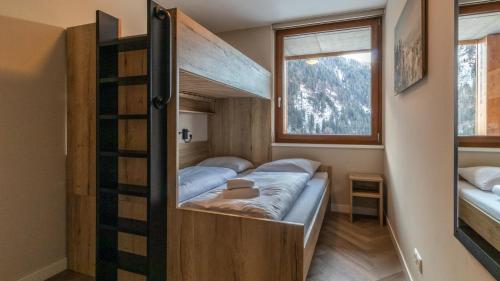 a bedroom with two bunk beds and a window at UplandParcs Silvretta in Schruns